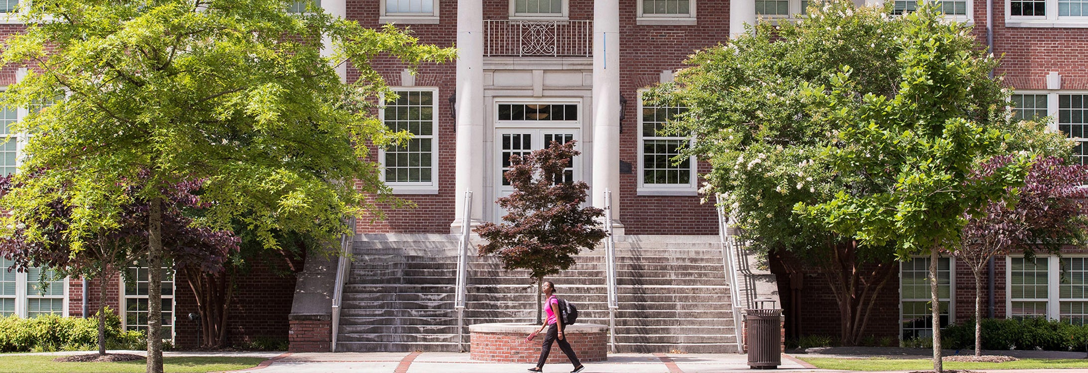 A student walks in front of Wright Auditorium